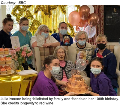 Julia Iverson being felicitated by family and friends on her 108th birthday. She credits longevity to red wine