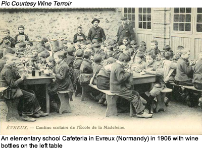 An elementary school Cafeteria in Evreux (Normandy) in 1906 with wine bottles on the left table